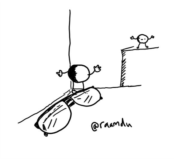 Two little round robots, one standing by a pair of glasses in a nook, one across a gap on a counter, happily waving at each other.