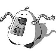 A roughly trapezoid-shaped robot with a rounded top and four wheels on its underside. It has two long, banded arms and an antenna. On its front is a rectangular window with rounded corners, and a person is visible sitting inside.