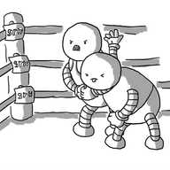 Two humanoid robots in a wrestling ring: one has the other in a headlock. The one being held has its eyes screwed shut and its tongue sticking out, while the aggressor looks very angry.